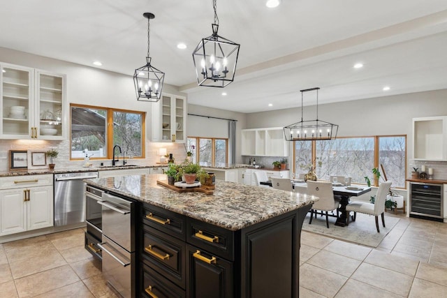 5400 N State Road 83, Hartland, WI 53029 - kitchen featuring stainless steel dishwasher, decorative backsplash, wine cooler, a kitchen island, and a chandelier