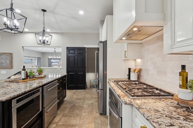 5400 N State Road 83, Hartland, WI 53029 - kitchen with white cabinetry, tasteful backsplash, custom range hood, appliances with stainless steel finishes, and a notable chandelier