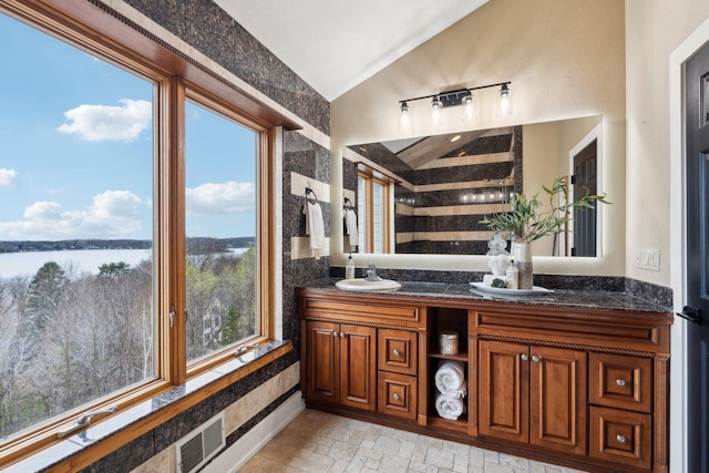 5400 N State Road 83, Hartland, WI 53029 - bathroom featuring visible vents, vanity, lofted ceiling, walk in shower, and a water view