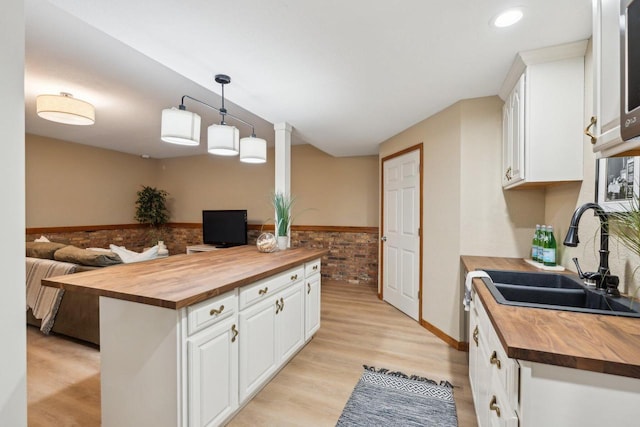 5400 N State Road 83, Hartland, WI 53029 - kitchen with a sink, wainscoting, butcher block counters, and white cabinets