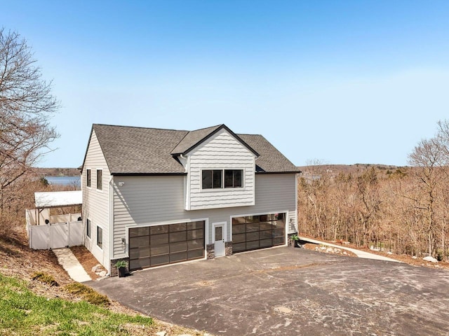 5400 N State Road 83, Hartland, WI 53029 - view of side of property featuring an attached garage, a shingled roof, and aphalt driveway