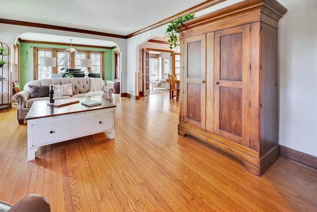 172 N St, Sun Prairie, WI 53590 - living room featuring arched walkways, light wood-style flooring, crown molding, and baseboards