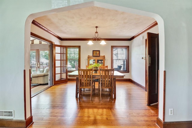 172 N St, Sun Prairie, WI 53590 - dining space featuring arched walkways, ornamental molding, light wood-style floors, french doors, and baseboards