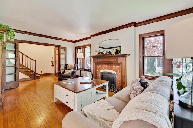 172 N St, Sun Prairie, WI 53590 - living room with plenty of natural light, stairway, a fireplace, light wood-type flooring, and crown molding