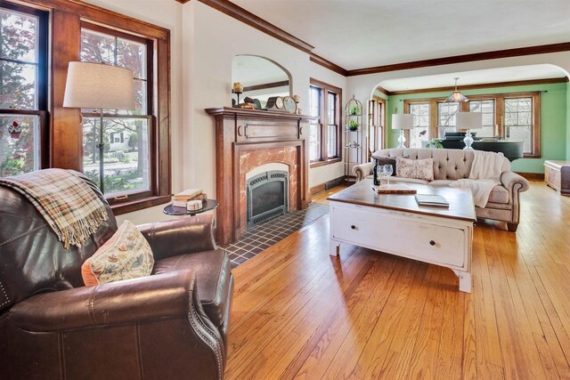 172 N St, Sun Prairie, WI 53590 - living room featuring crown molding, healthy amount of natural light, light wood-style flooring, and a premium fireplace