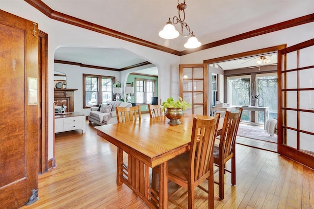 172 N St, Sun Prairie, WI 53590 - dining space featuring arched walkways, light wood finished floors, and crown molding