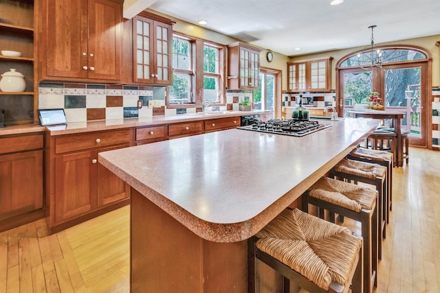 172 N St, Sun Prairie, WI 53590 - kitchen with brown cabinetry, stainless steel gas stovetop, light wood-style flooring, and recessed lighting
