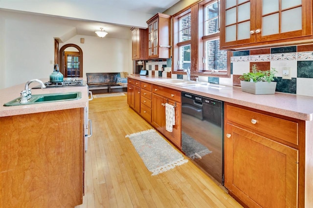 172 N St, Sun Prairie, WI 53590 - kitchen with black dishwasher, a sink, brown cabinetry, light wood-style flooring, and light countertops