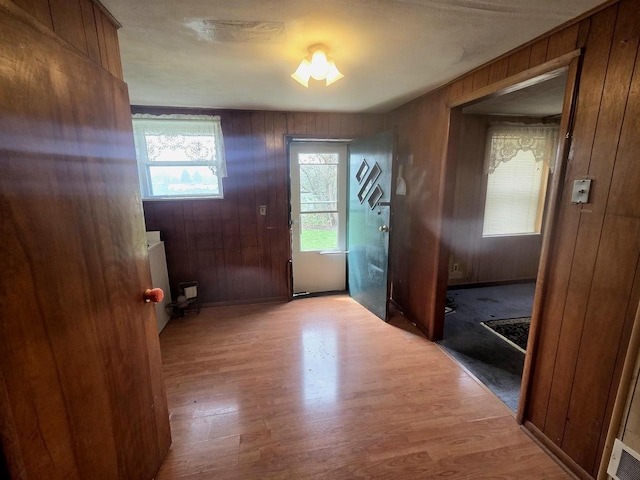 entryway featuring wood walls and wood finished floors