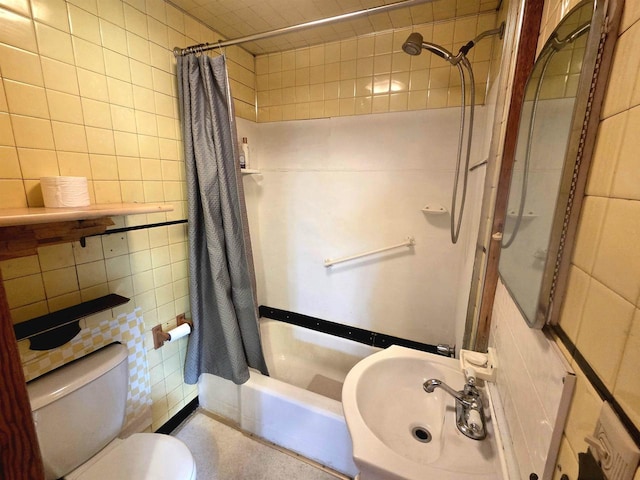 full bath with a sink, tile walls, toilet, and shower / tub combo
