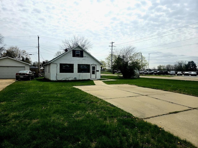 view of front of home featuring a front lawn, an outbuilding, and a detached garage