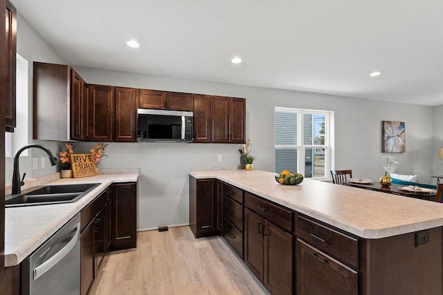 433 Scott St, Ripon, WI 54971 - kitchen featuring dark brown cabinetry, a peninsula, appliances with stainless steel finishes, and a sink