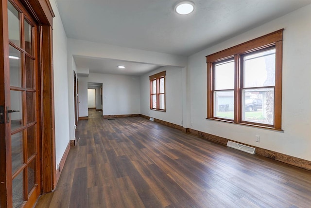 empty room featuring recessed lighting, visible vents, dark wood-style flooring, and baseboards