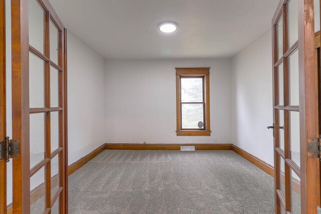 unfurnished room with visible vents, carpet floors, and french doors