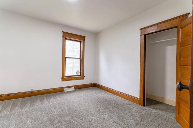 unfurnished bedroom featuring baseboards, visible vents, a closet, and carpet flooring
