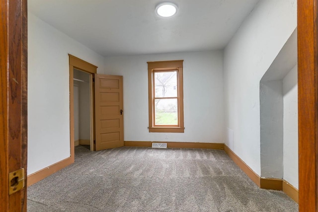 interior space featuring baseboards, visible vents, and carpet floors