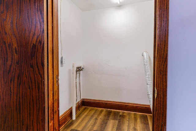 interior space featuring wood finished floors, laundry area, and baseboards