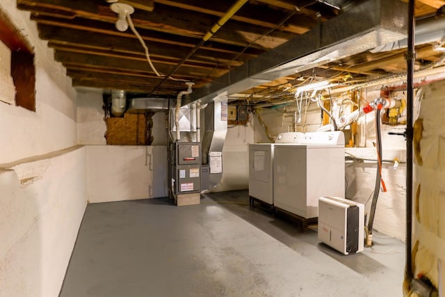 unfinished below grade area with heating unit and separate washer and dryer