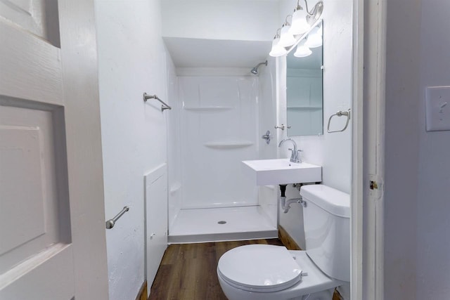 bathroom featuring wood finished floors, walk in shower, and toilet