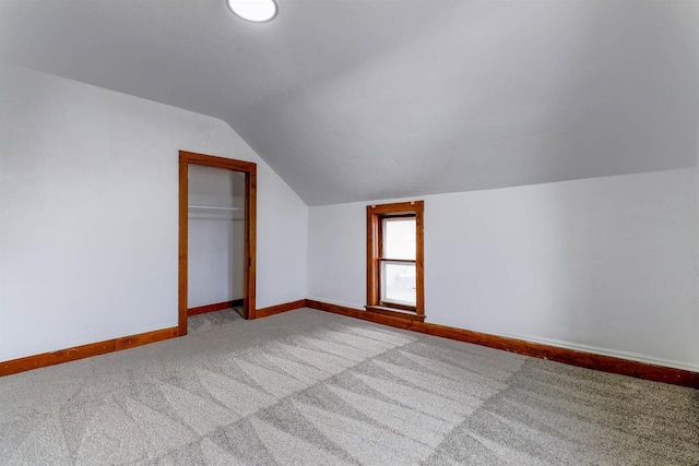 bonus room with baseboards, vaulted ceiling, and carpet floors
