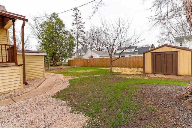 view of yard with an outdoor structure, a storage shed, and fence