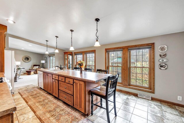8795 County Rd S, Pulaski, WI 54162 - kitchen with a sink, brown cabinets, a healthy amount of sunlight, visible vents, and dishwasher