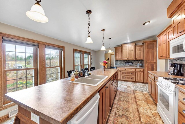 8795 County Rd S, Pulaski, WI 54162 - kitchen with tasteful backsplash, white appliances, decorative light fixtures, a sink, and a center island with sink