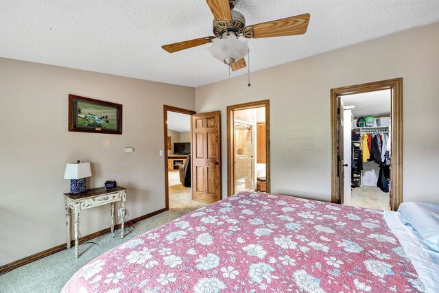 8795 County Rd S, Pulaski, WI 54162 - carpeted bedroom featuring baseboards, ensuite bath, ceiling fan, a walk in closet, and a textured ceiling