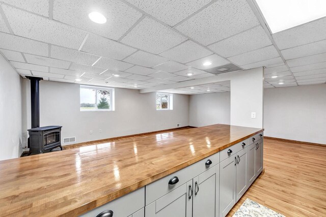 8795 County Rd S, Pulaski, WI 54162 - kitchen featuring a wood stove, wood counters, light wood-type flooring, visible vents, and open floor plan