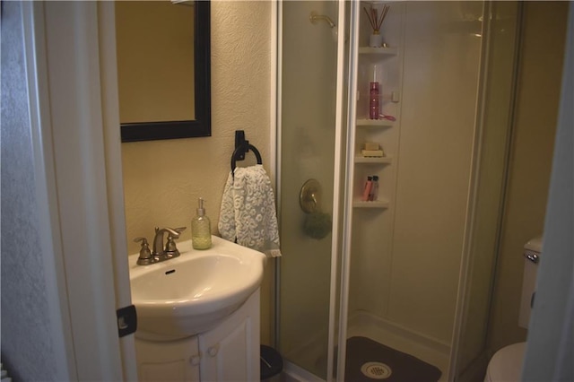 903 Wilson Ave, Rice Lake, WI 54868 - full bath with toilet, a textured wall, a shower stall, and vanity