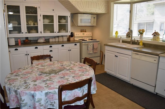 903 Wilson Ave, Rice Lake, WI 54868 - kitchen featuring white appliances, glass insert cabinets, white cabinets, dark countertops, and a sink
