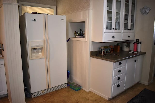 903 Wilson Ave, Rice Lake, WI 54868 - kitchen featuring white fridge with ice dispenser, white cabinets, dark countertops, and glass insert cabinets