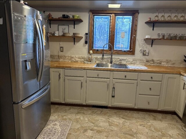 W4609 S Pearl Lake Rd, Redgranite, WI 54970 - kitchen with stainless steel fridge with ice dispenser, a sink, open shelves, and wood counters