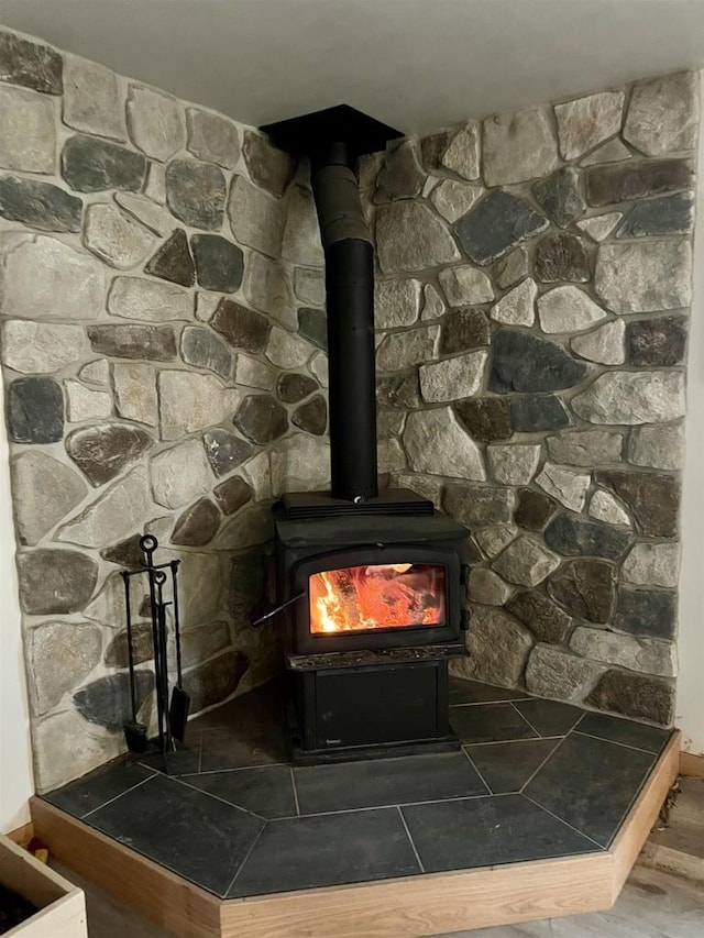 room details with a wood stove, baseboards, and wood finished floors