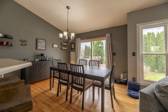 dining room with an inviting chandelier, light wood-style floors, and high vaulted ceiling