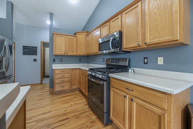 kitchen with light countertops, stainless steel appliances, and light wood finished floors