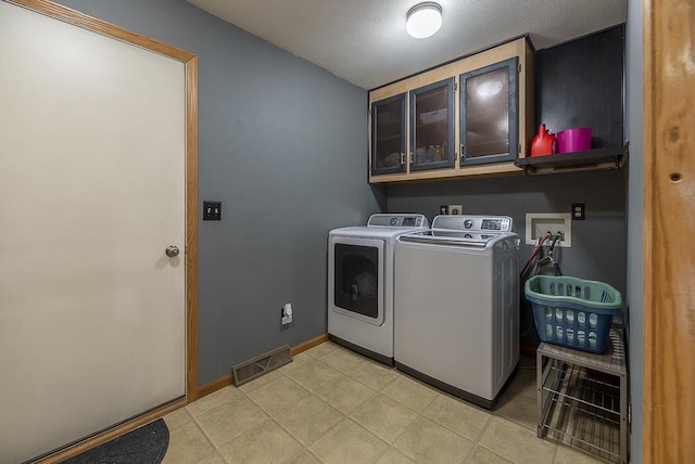 clothes washing area featuring visible vents, baseboards, a textured ceiling, cabinet space, and independent washer and dryer