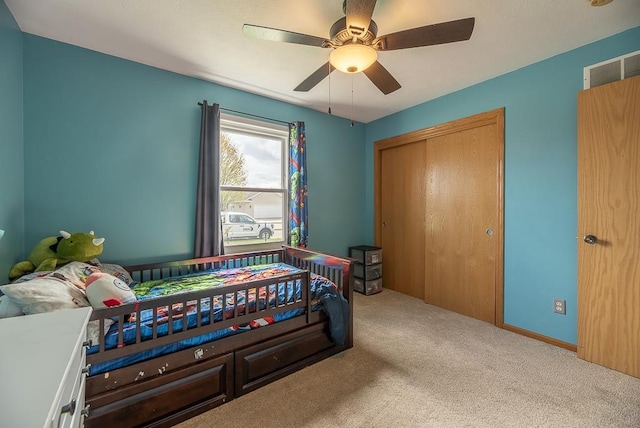 carpeted bedroom with ceiling fan, visible vents, and a closet