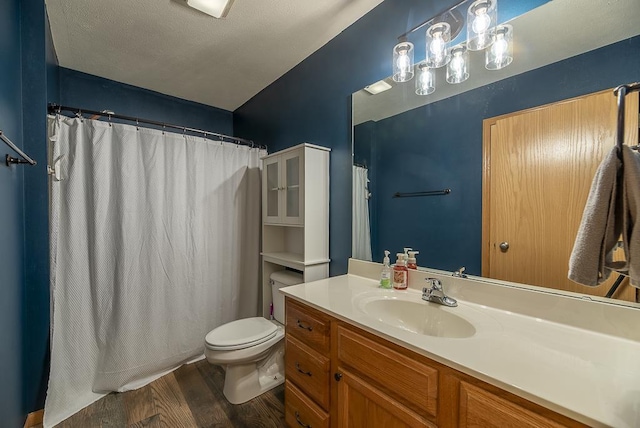 bathroom featuring vanity, wood finished floors, toilet, and curtained shower