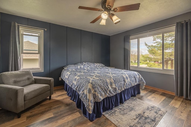 bedroom featuring baseboards, a ceiling fan, a textured ceiling, and wood finished floors