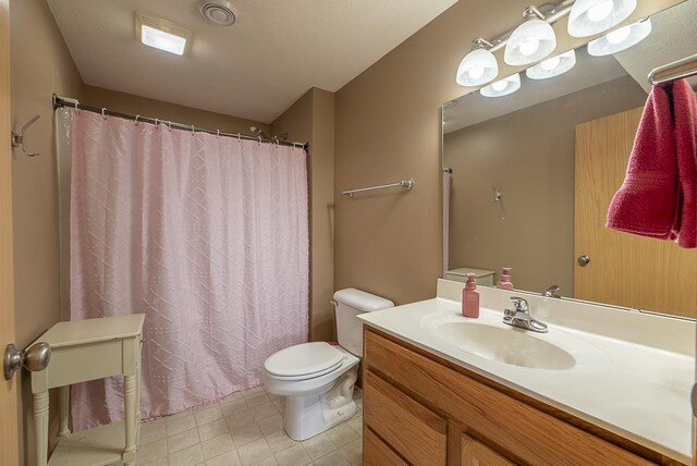 full bathroom with toilet, visible vents, a shower with shower curtain, and vanity
