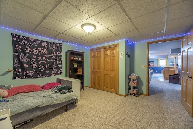 bedroom featuring carpet floors, a closet, and a paneled ceiling