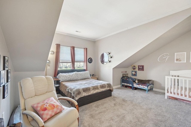 carpeted bedroom featuring lofted ceiling, visible vents, ornamental molding, and baseboards