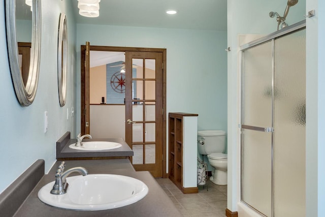 full bath with toilet, a stall shower, and a sink