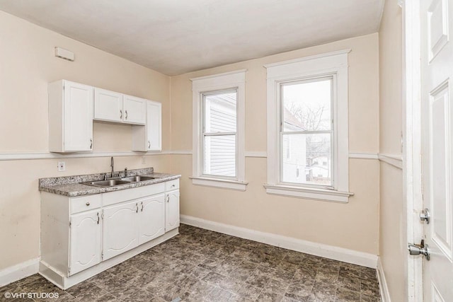 2968 N Buffum St Unit 2968A, Milwaukee, WI 53212 - kitchen featuring dark floors, light countertops, white cabinets, a sink, and baseboards
