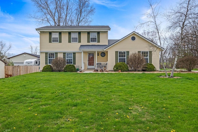 traditional-style home featuring a front lawn and fence