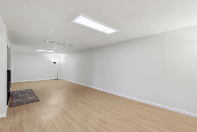 basement with light wood-type flooring and baseboards