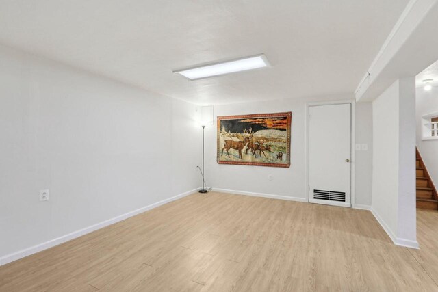 spare room with stairs, baseboards, and light wood finished floors