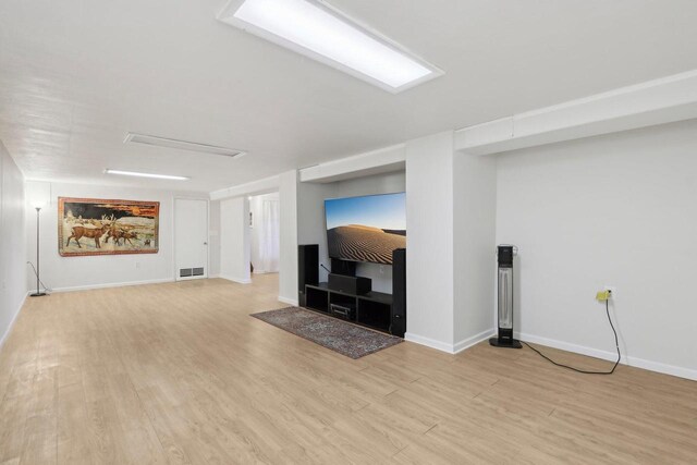 unfurnished living room with baseboards, visible vents, and light wood-style floors
