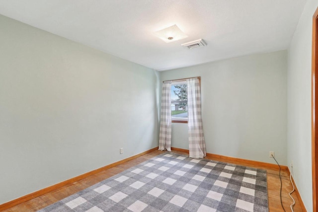 spare room with baseboards and visible vents